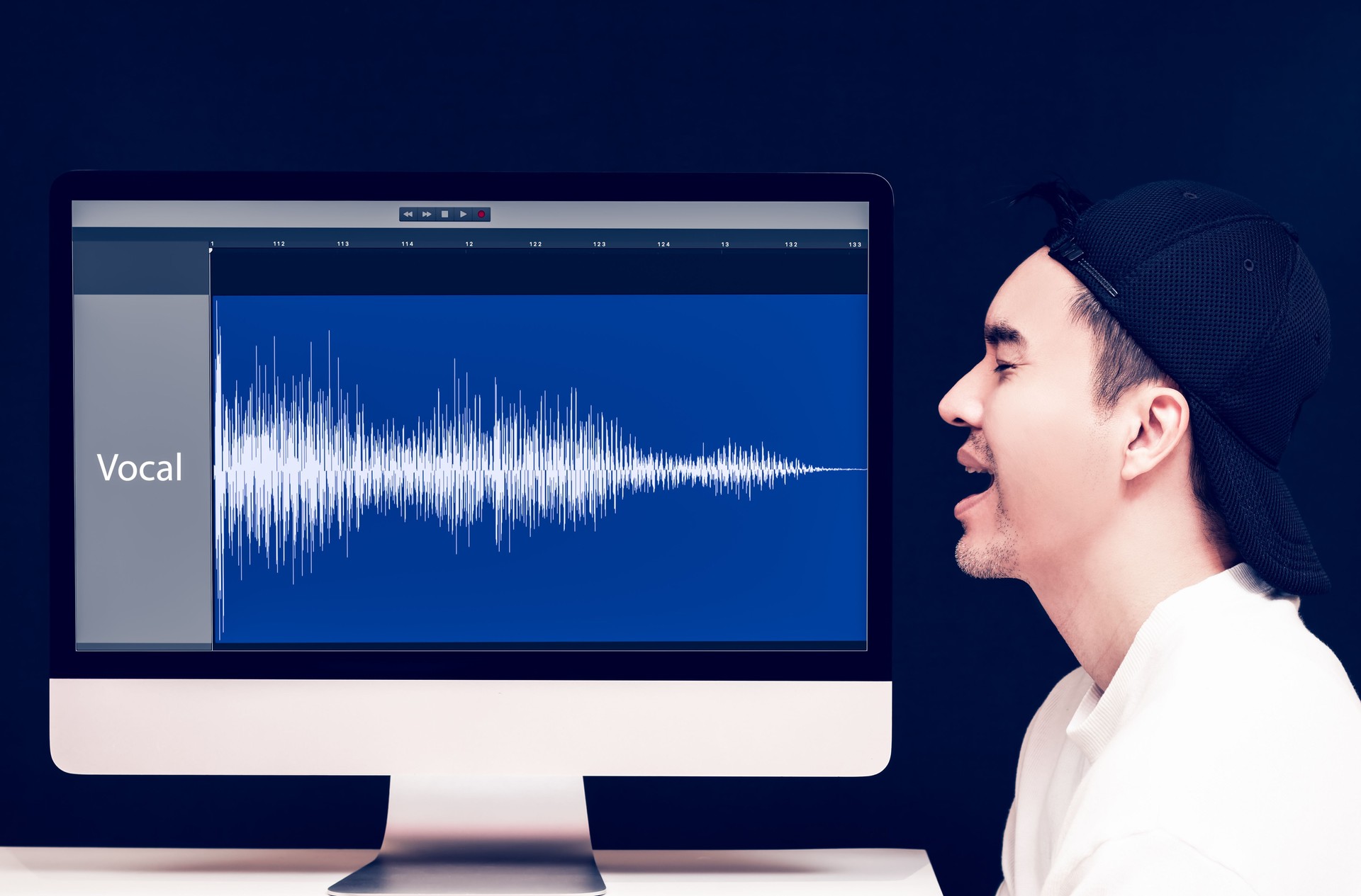 vocal, voice recording concept. asian male singer singing beside waveform on computer display look like his voice become digital waveform on digital audio workstation application