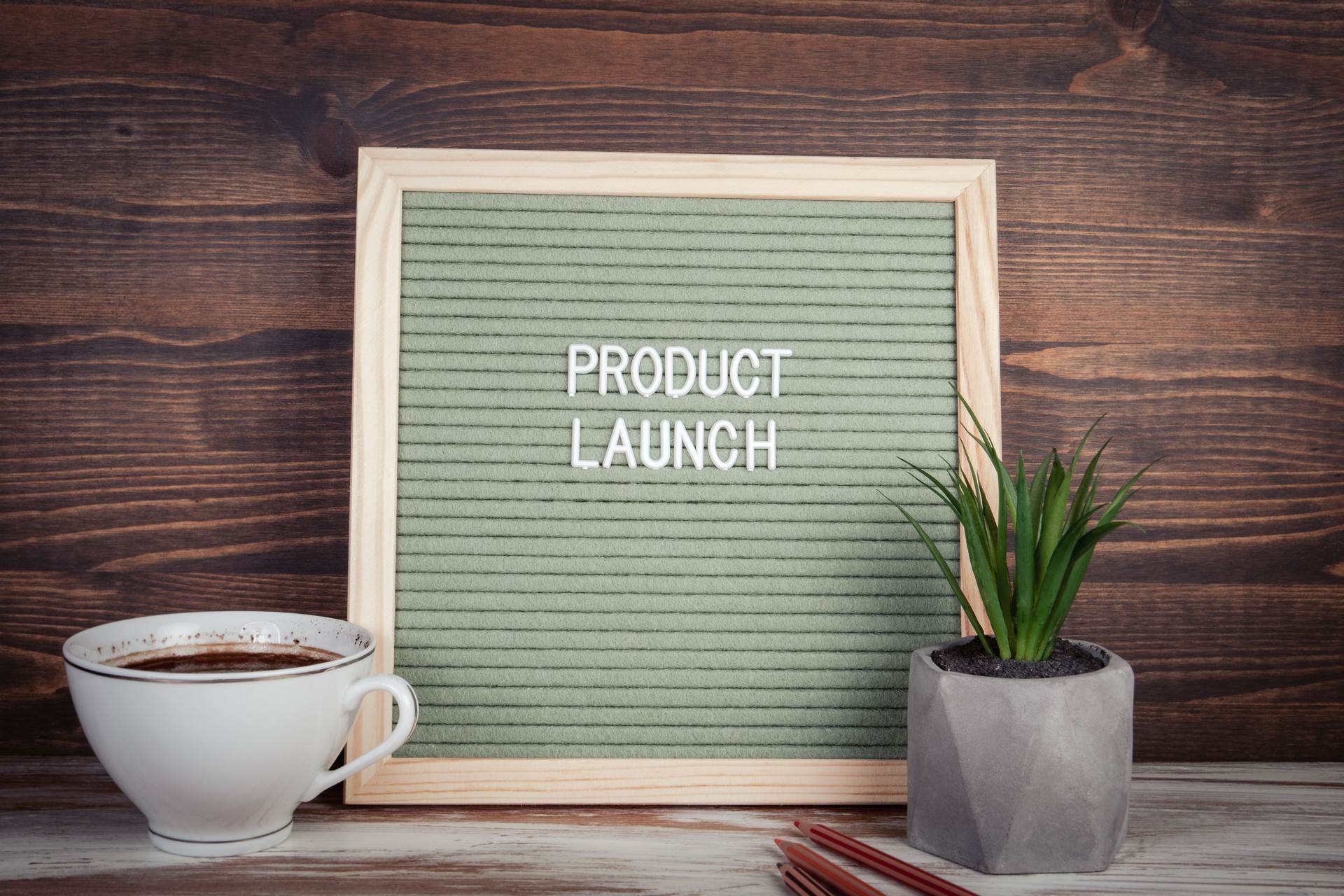 Product Launch. English text on a letter Board. Stationery on a wooden table
