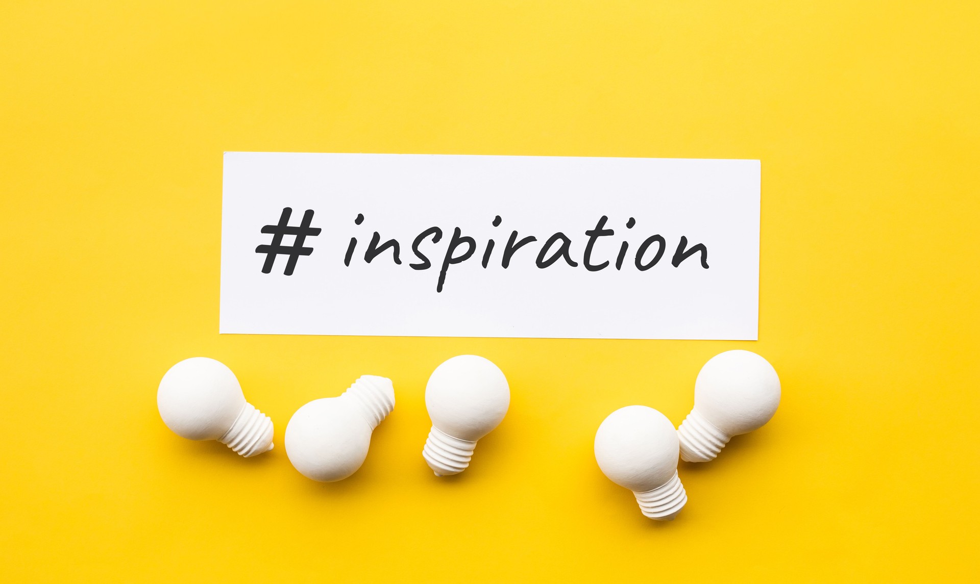 Business creativity with inspiration text and lightbulb on yellow background